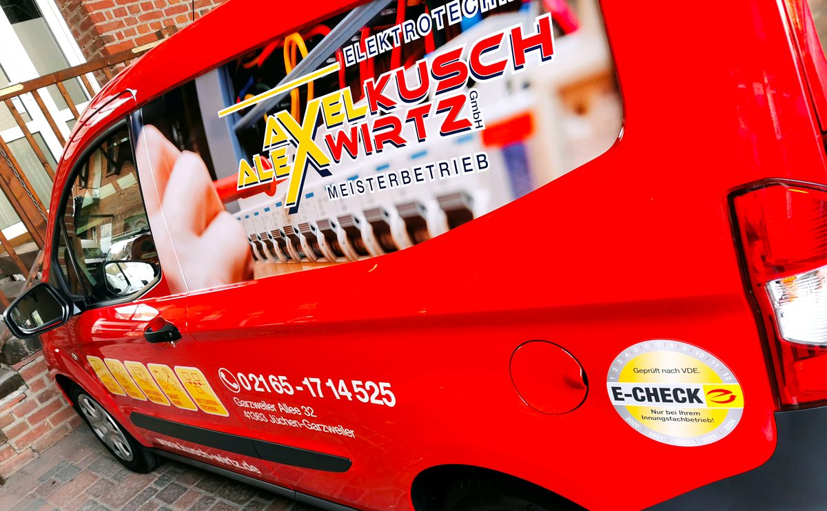 Roter Firmenwagen von Kusch & Wirtz mit Logo, E-Check-Plakette und Adresse Garzweiler Allee 32